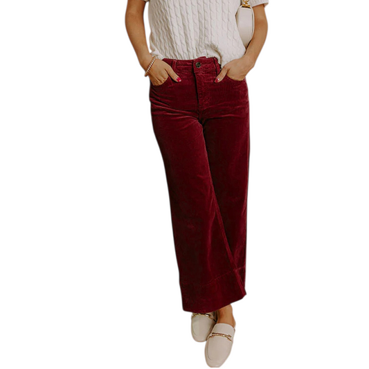Person wearing burgundy high-rise wide-leg corduroy trousers with a white knit sweater and cream loafers.