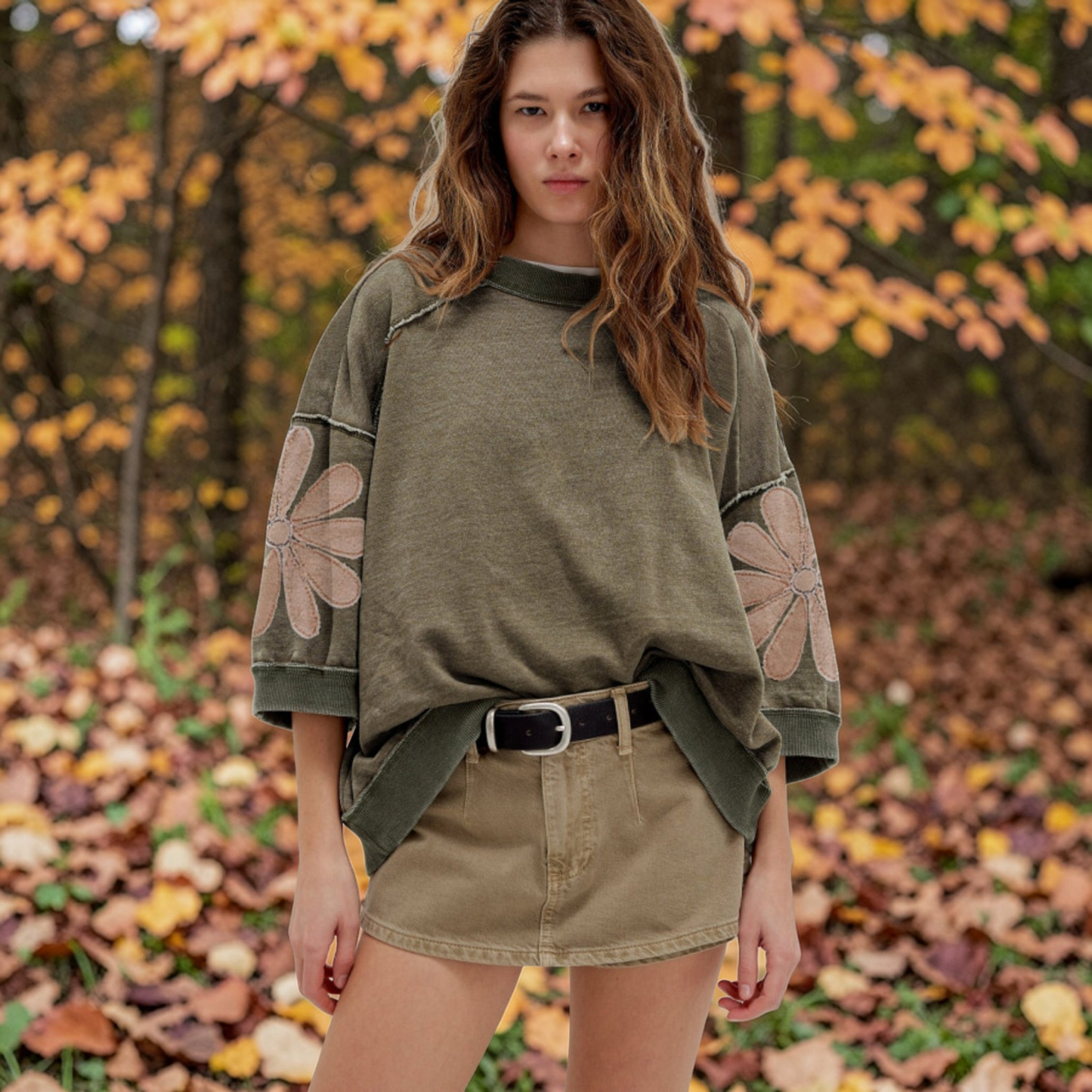 A model showcasing the mineral wash sweatshirt in a natural autumn outdoor setting, emphasizing its earthy tones and cozy, transitional season style.