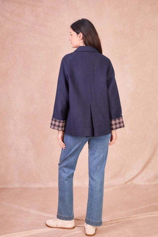 Rear view of a navy wool-blend jacket showing the back pleat detail and relaxed, slightly oversized silhouette.