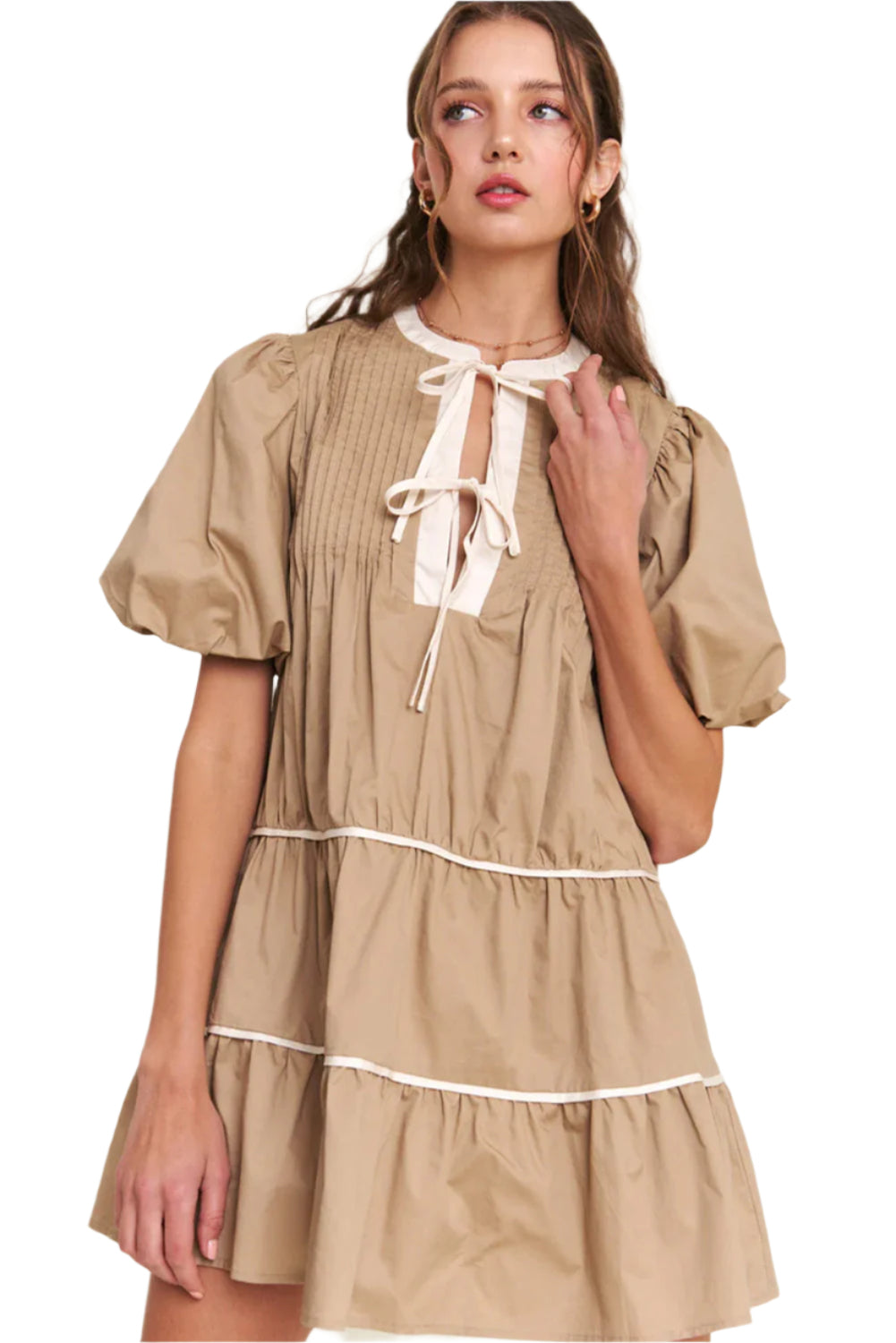 Woman in a pale khaki knot front mini dress with pleated tiered design, perfect for summer events and casual outings.
