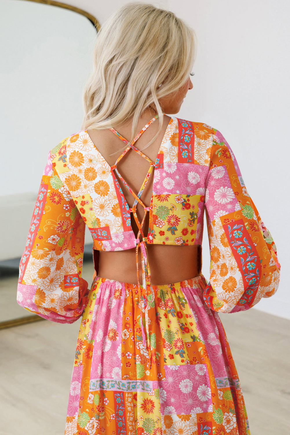 Woman wearing a colorful floral two-piece outfit with a white background