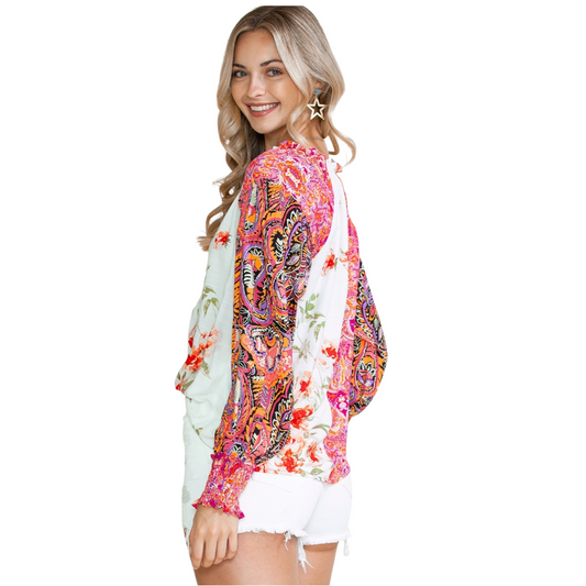 Back view of a woman wearing a multi-coloured patchwork floral viscose blouse with a V-neckline and button-down front.