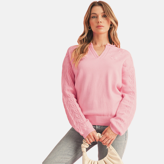 Pink floral embroidery cable sleeve knit sweater styled with grey jeans and cream ruched handbag front view