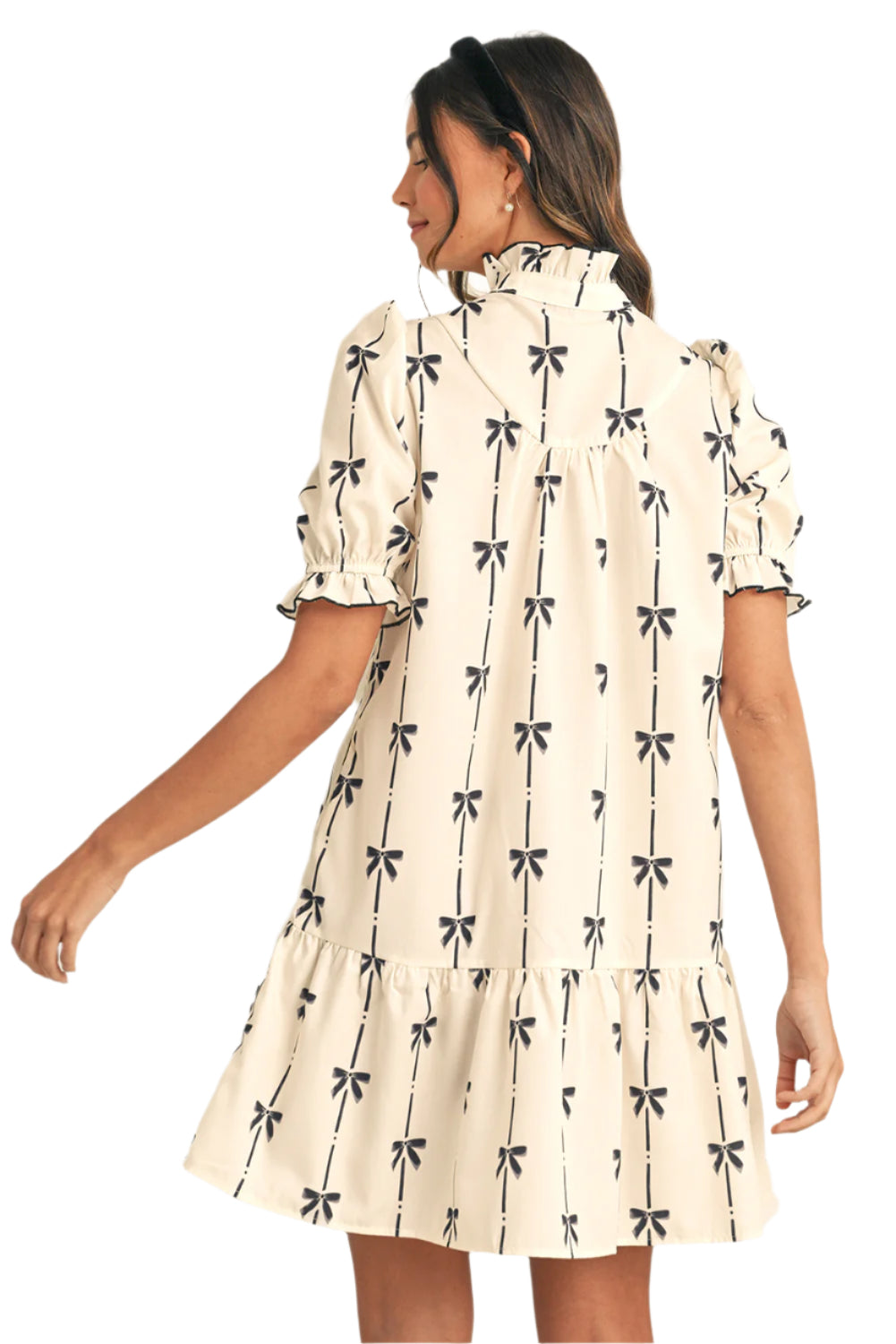 Back view of a beige mini dress featuring a bow print, designed with a lightweight fabric ideal for summer.