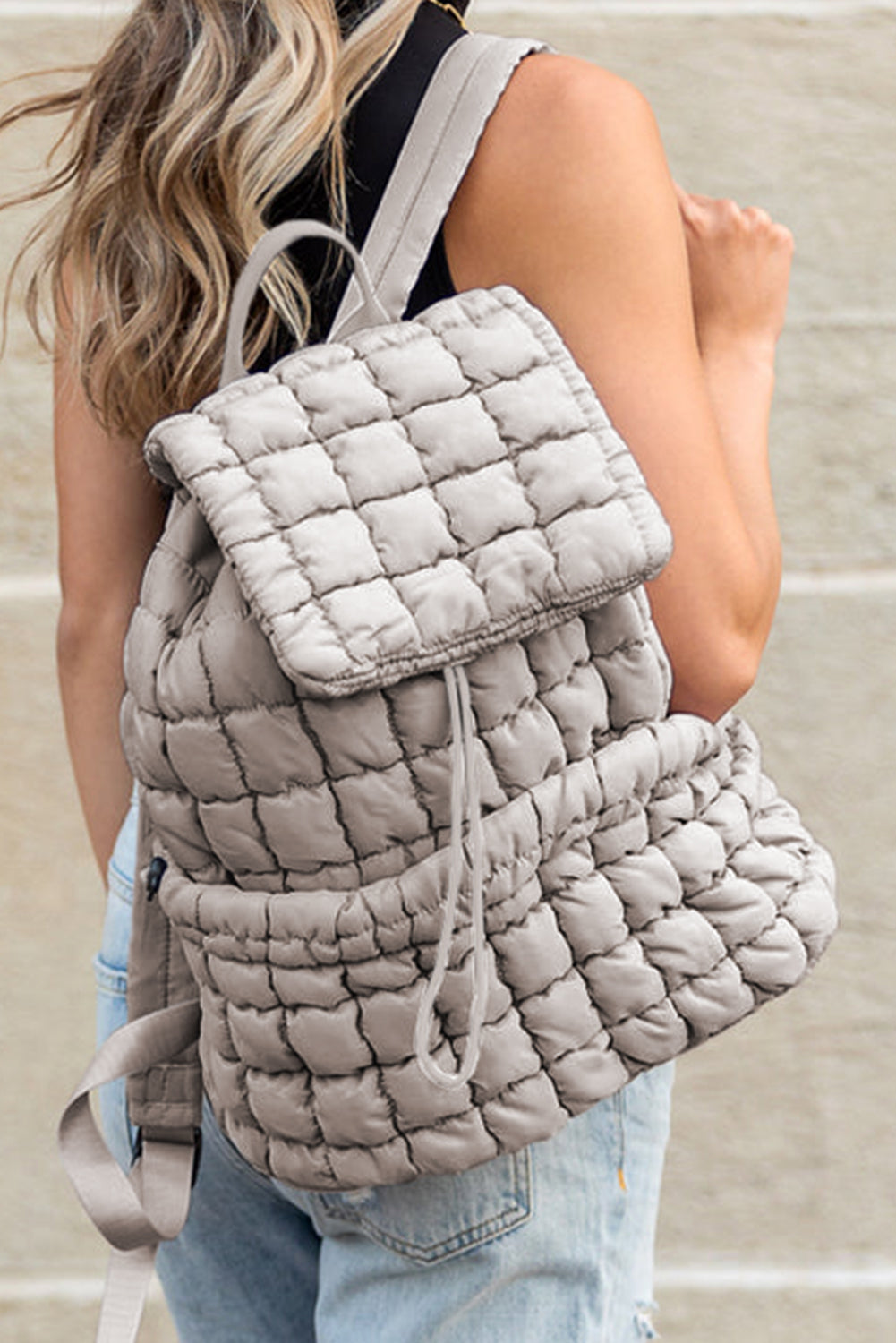 Grey quilted puffer backpack for women.