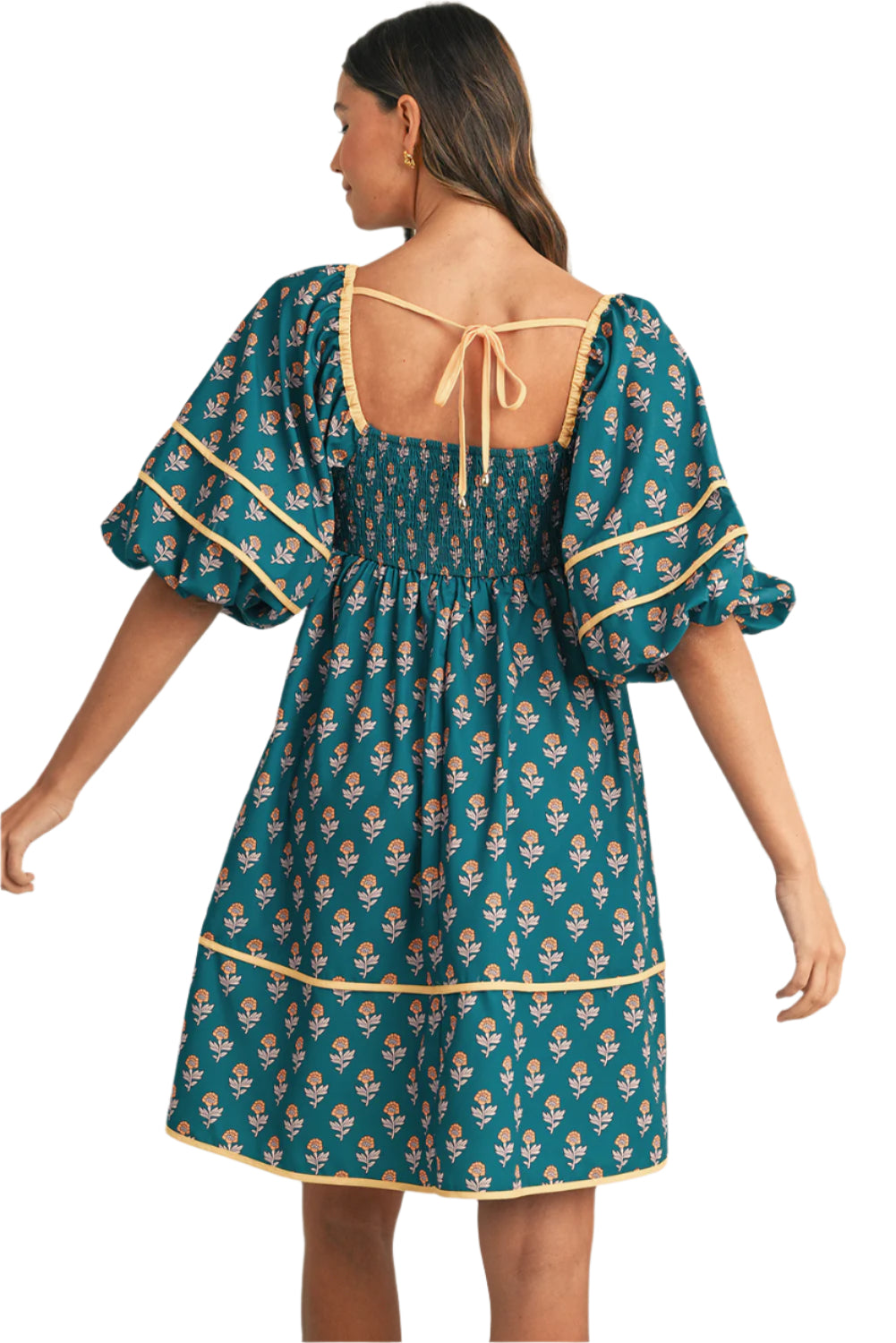 Back view of a teal floral pleated mini dress with bishop sleeves.