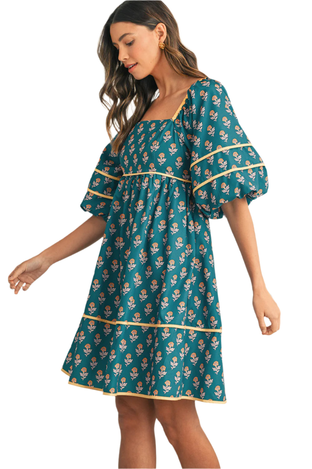 Side view of a teal floral pleated mini dress with bishop sleeves.