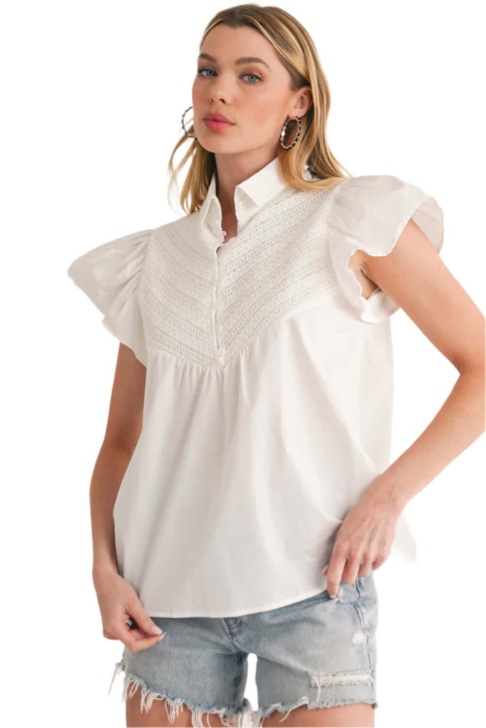 Front view of white blouse featuring crochet patchwork and airy ruffle sleeves.