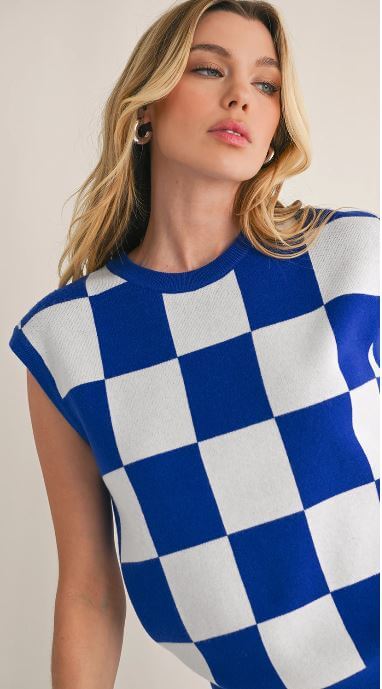 Close-up of a sleeveless knit top with a bold blue and white check pattern.