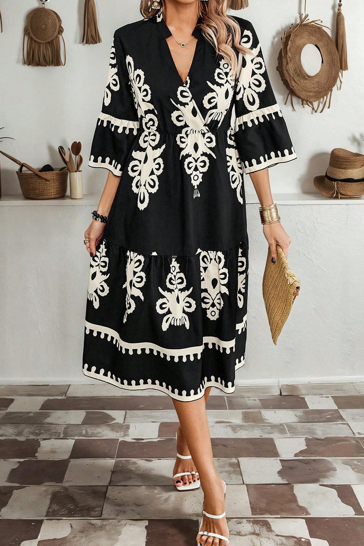 Front view of model wearing a black and white abstract ethnic print midi dress.