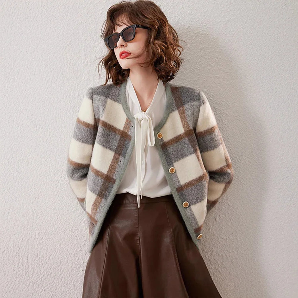 Woman wearing a plaid cardigan, white blouse, and brown leather skirt against a light background - women's tailored jackets