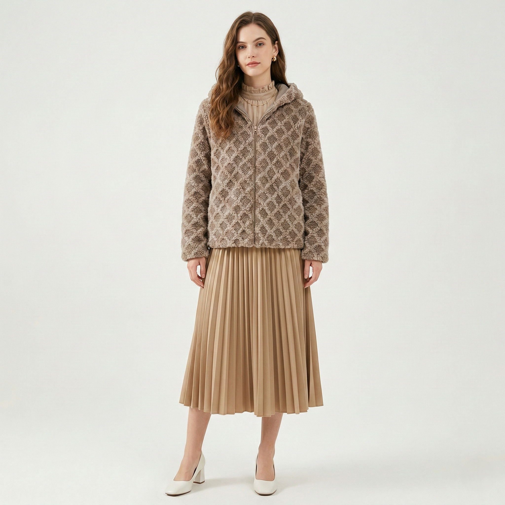 A woman wearing a modern colourblock plaid cardigan featuring textured pink, blue, brown, and olive green squares with gold-toned buttons.