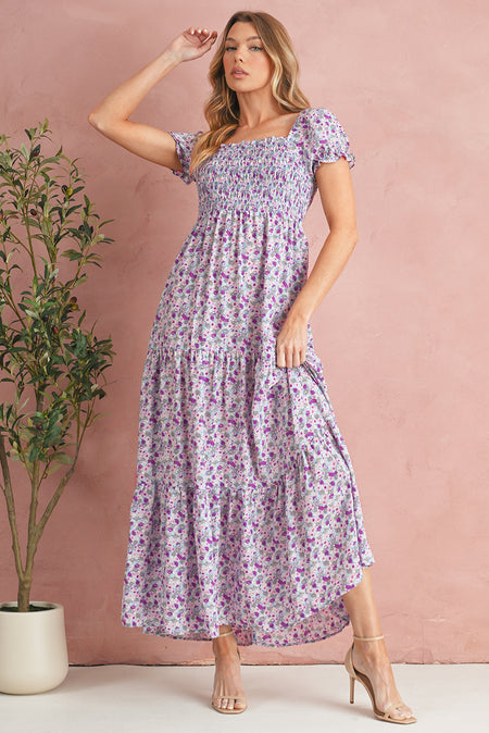 Woman wearing a floral dress against a pink background