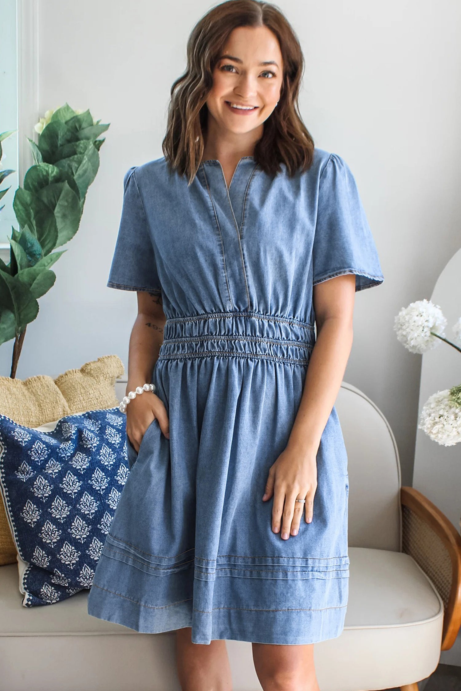 Women's wearing a contrast stick smock waist denim mini dress with short sleeves