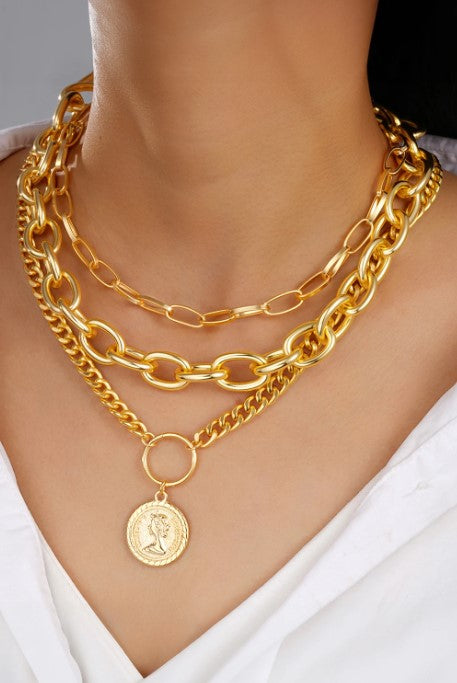 Set of polished gold chains on model's neck.