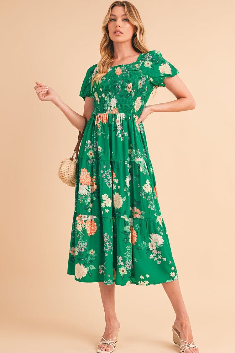 Full front view of a green floral midi dress with short bracelet sleeves, modeled for a stylish look.