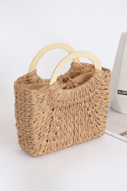 Beige woven handbag with wooden handles on a white surface