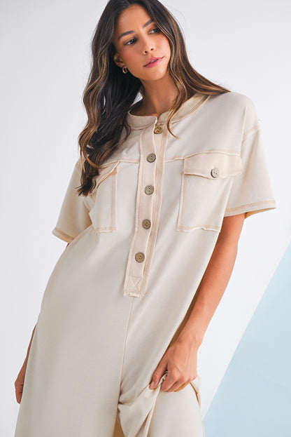 Woman wearing a beige dress with button details against a white background