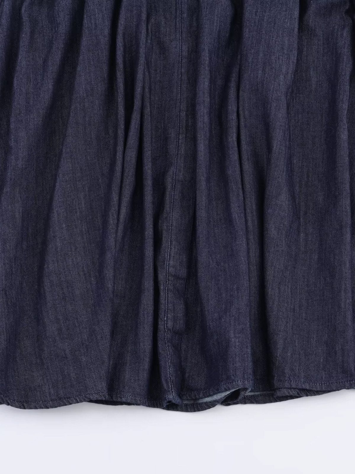 Catherine Martin dark indigo denim fabric with soft vertical pleats and visible stitching detail
