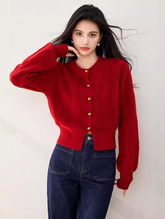 Catherine Martin red cropped knit cardigan with gold buttons worn by a model with dark hair against a white wall