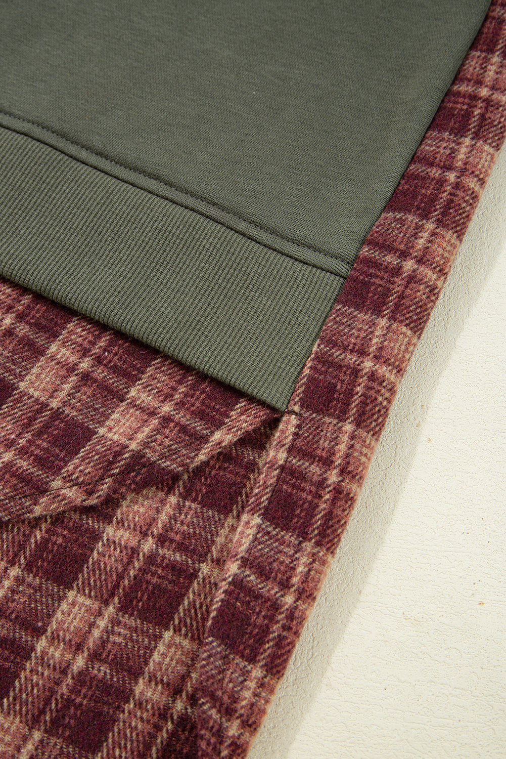 Close-up of green fabric and red plaid fabric corner