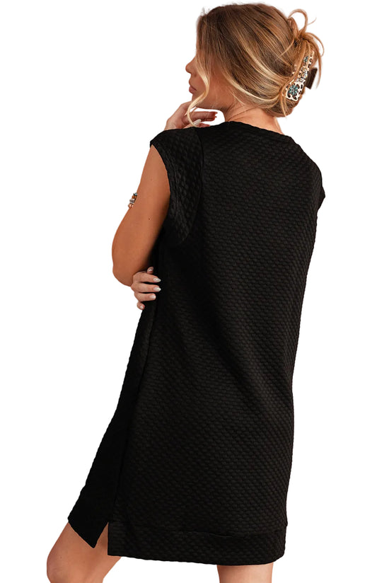 Woman wearing a black sleeveless dress against a white background