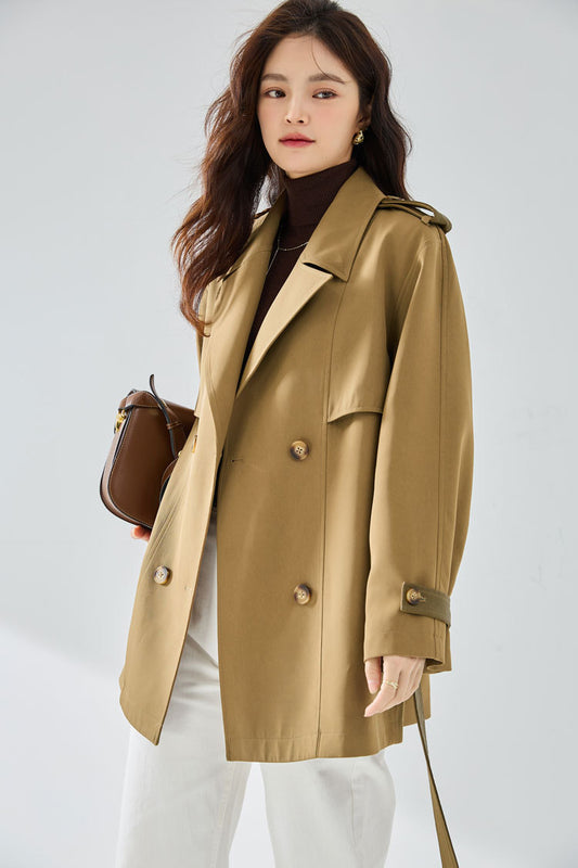 Woman wearing a beige trench coat with a white background
