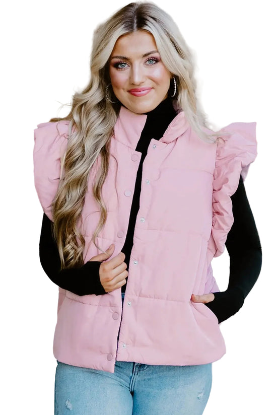 Woman wearing a pink puffer vest over a black top with a blurred background
