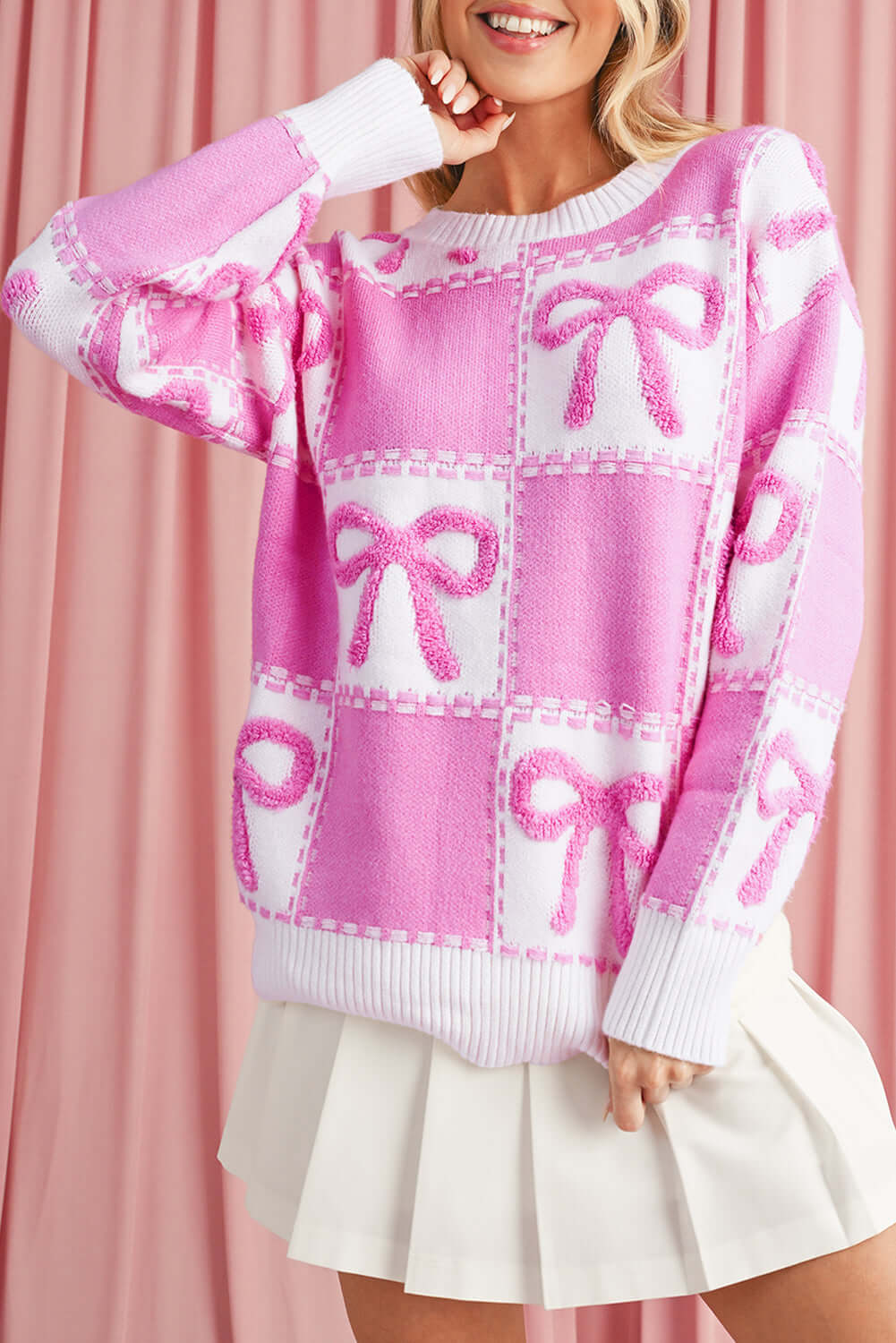 Trendy pink bow sweater styled with a skirt, perfect for Aussie winter.
