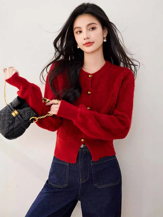Catherine Martin red cropped knit cardigan with gold buttons worn by a woman with a black quilted handbag