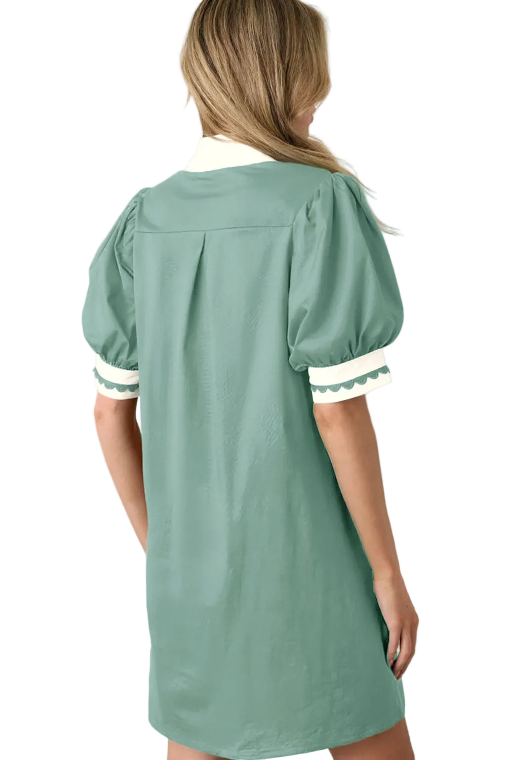 Green dress with white trim on a beige background