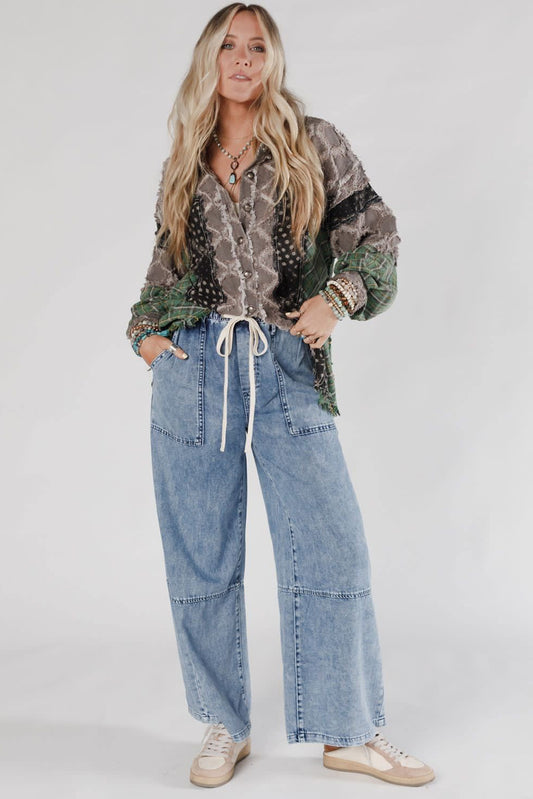Woman wearing a patterned shirt and jeans on a white background