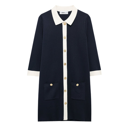 flat lay image of the dark blue knit mini polo dress, showing the striking cream contrast collar and placket accented with decorative gold buttons and front patch pockets.
