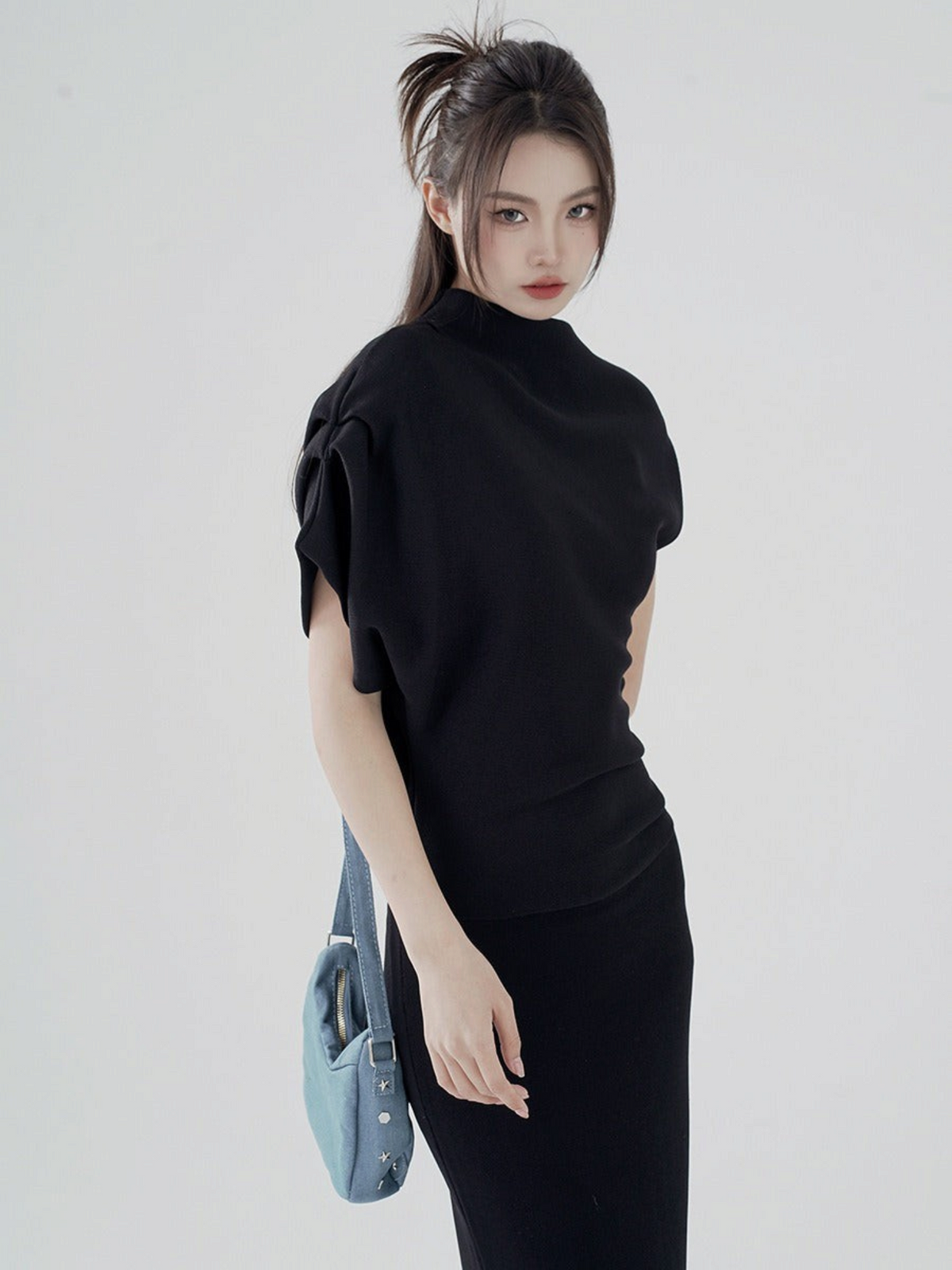 Catherine Martin black viscose-nylon two-piece set with a funnel neck top, asymmetric sleeve, and fitted midi skirt.