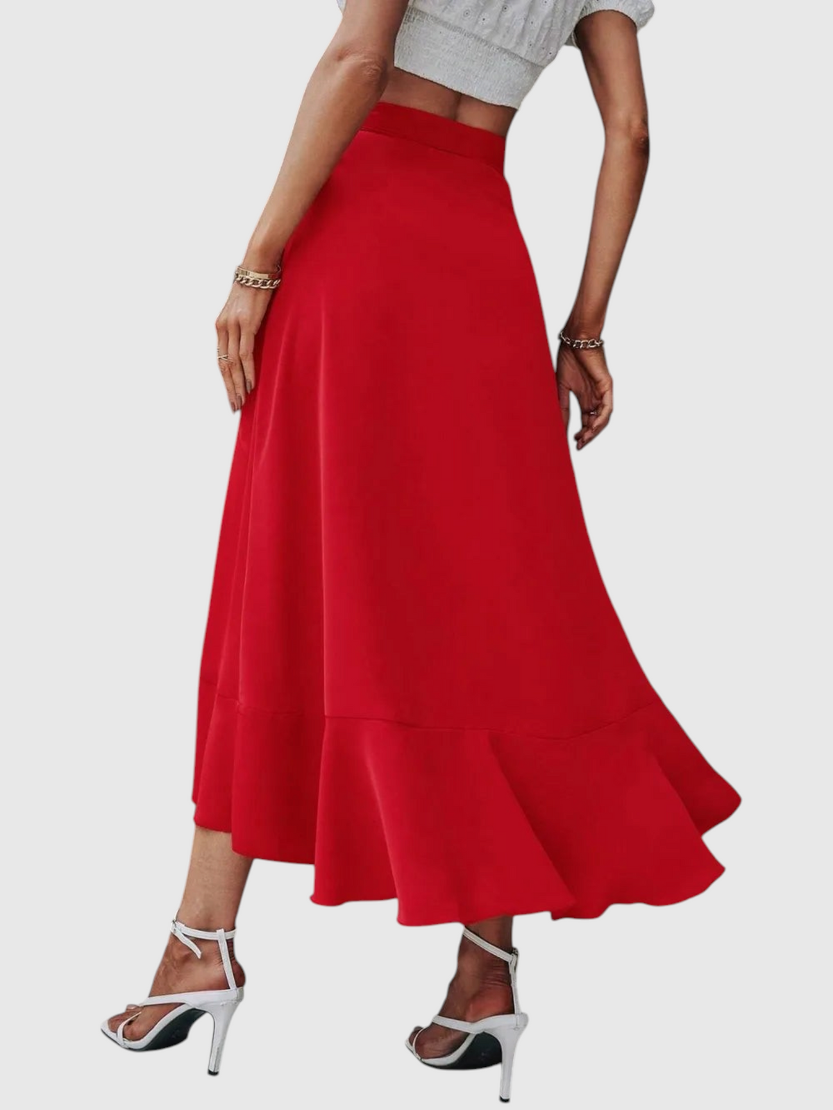 Catherine Martin red midi wrap skirt with ruffle hem and side tie, worn with white heels against a rustic door.