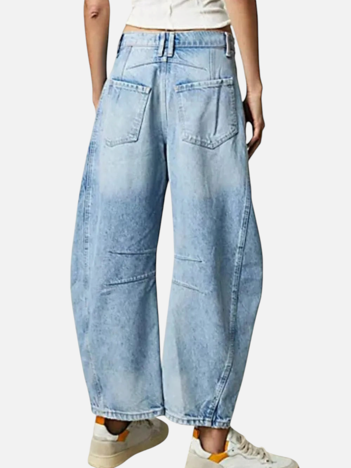Catherine Martin light wash barrel leg jeans with a cropped hem and back pocket detail worn with white sneakers.
