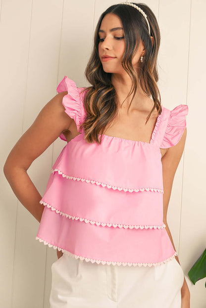 Model styling a pink ruffle camisole for a relaxed beach look in Australia.

