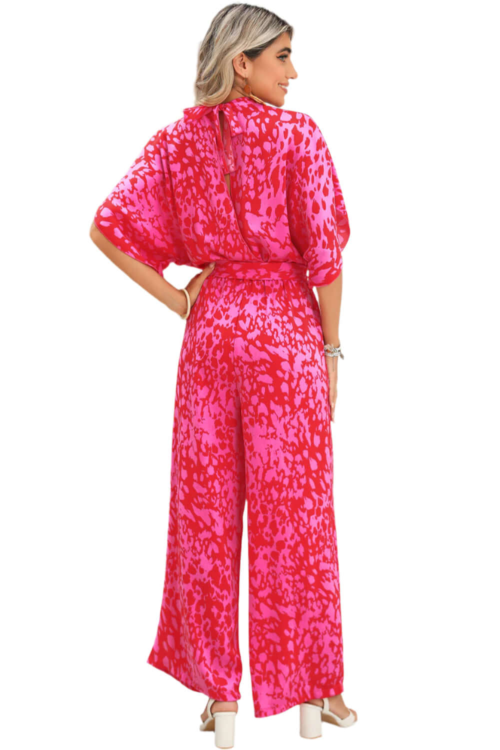 Flowy wide-leg jumpsuit in a striking pink print, perfect for parties.
