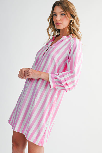 Woman wearing a pink and white striped dress on a white background