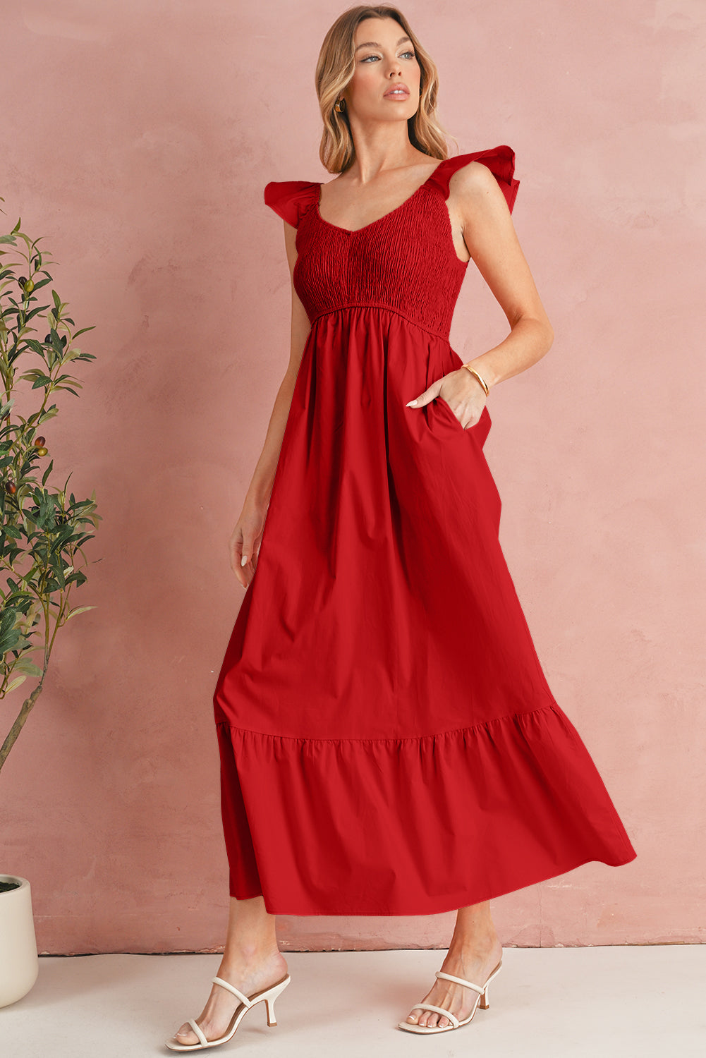 Woman wearing a red dress against a pink background