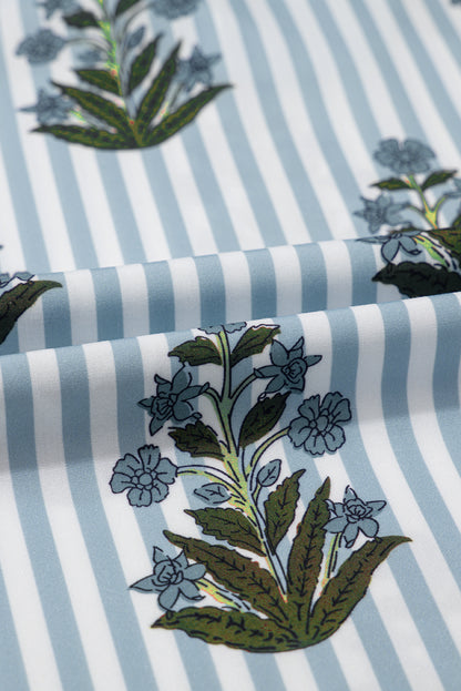 Close-up of blue floral striped fabric with long sleeves and tie neckline, perfect for spring and summer, from Catherine Martin store.