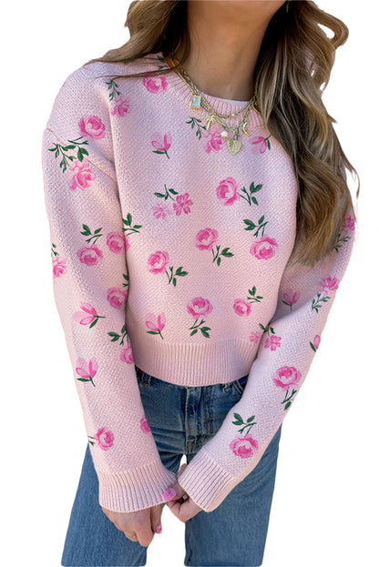 Pink floral sweater worn by a person on a white background