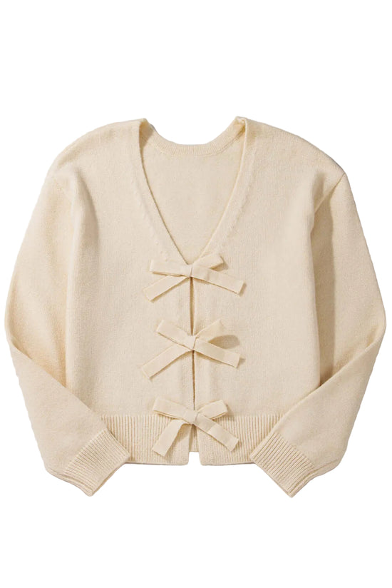 Flat lay of a cream knit cardigan with bow details, ideal for casual or dressy outfits.
