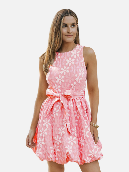 Catherine Martin coral pink sleeveless mini dress with a textured floral jacquard pattern and adjustable waist tie.