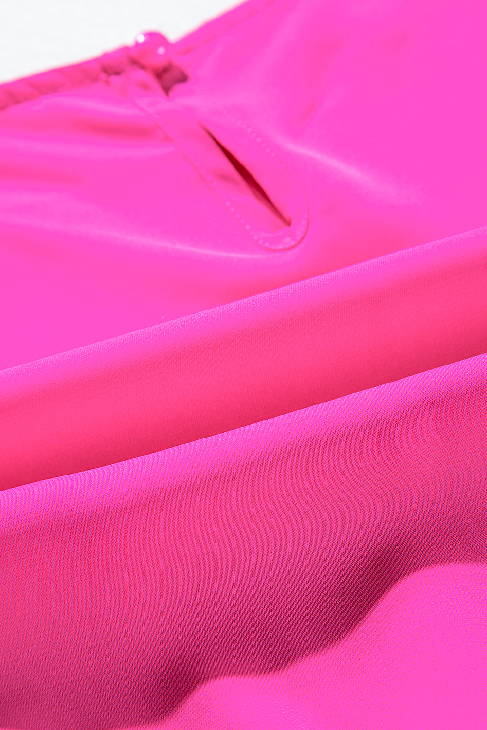 Close-up of fabric on bright pink pleated layered ruffle sleeveless mini dress.