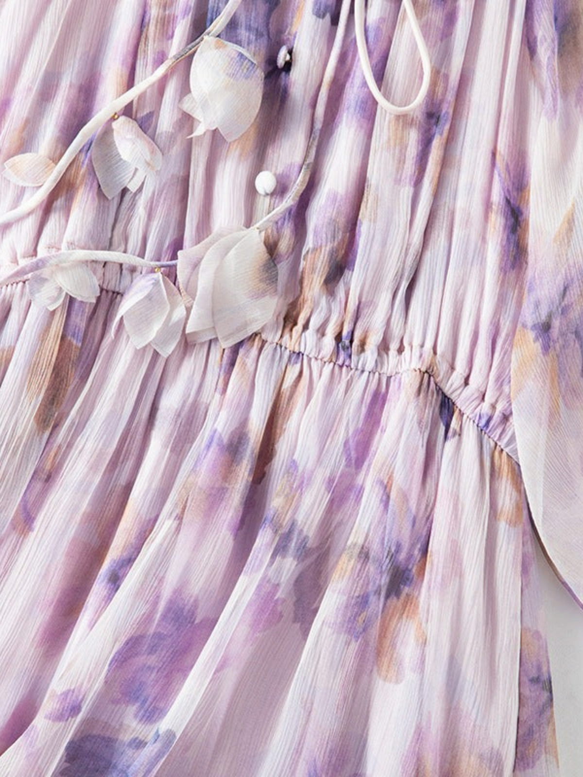 Catherine Martin lilac floral chiffon dress with a ruffled tie neck, petal details, and an elasticated waist.