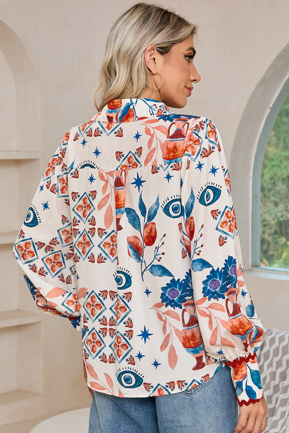 Back view of a model standing in a multicolour ethnic floral print shirt with long sleeves.