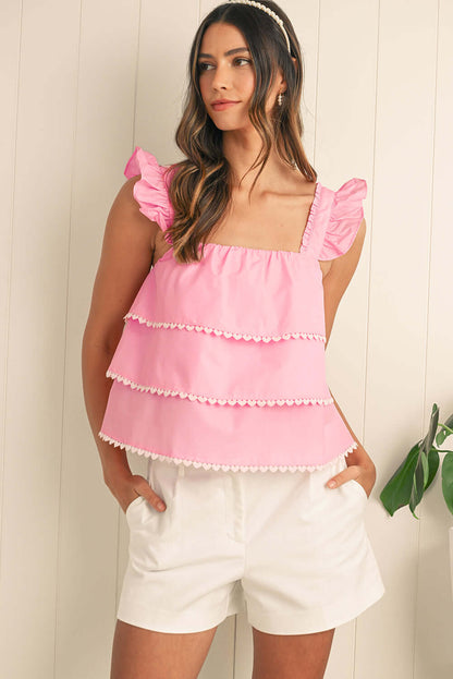 Pink summer top with scalloped trim, a trendy choice for warm-weather outings.
