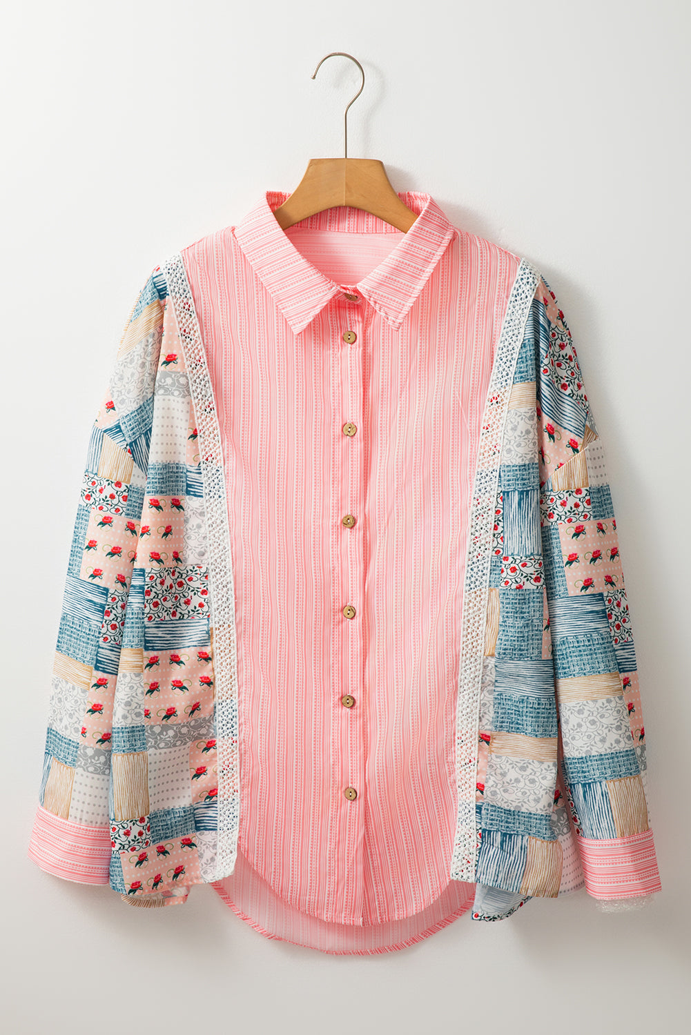 Full front view of a stylish pink floral patchwork long sleeve shirt on a hanger.