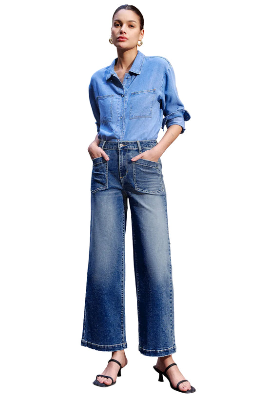 Woman wearing a blue denim outfit standing on a street.